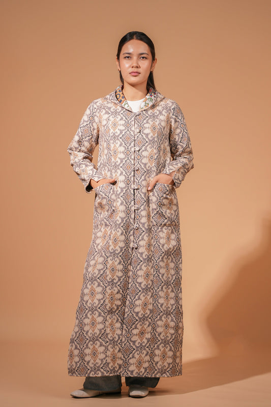 Woman wearing the reversible hooded chapan on its beige geometric side