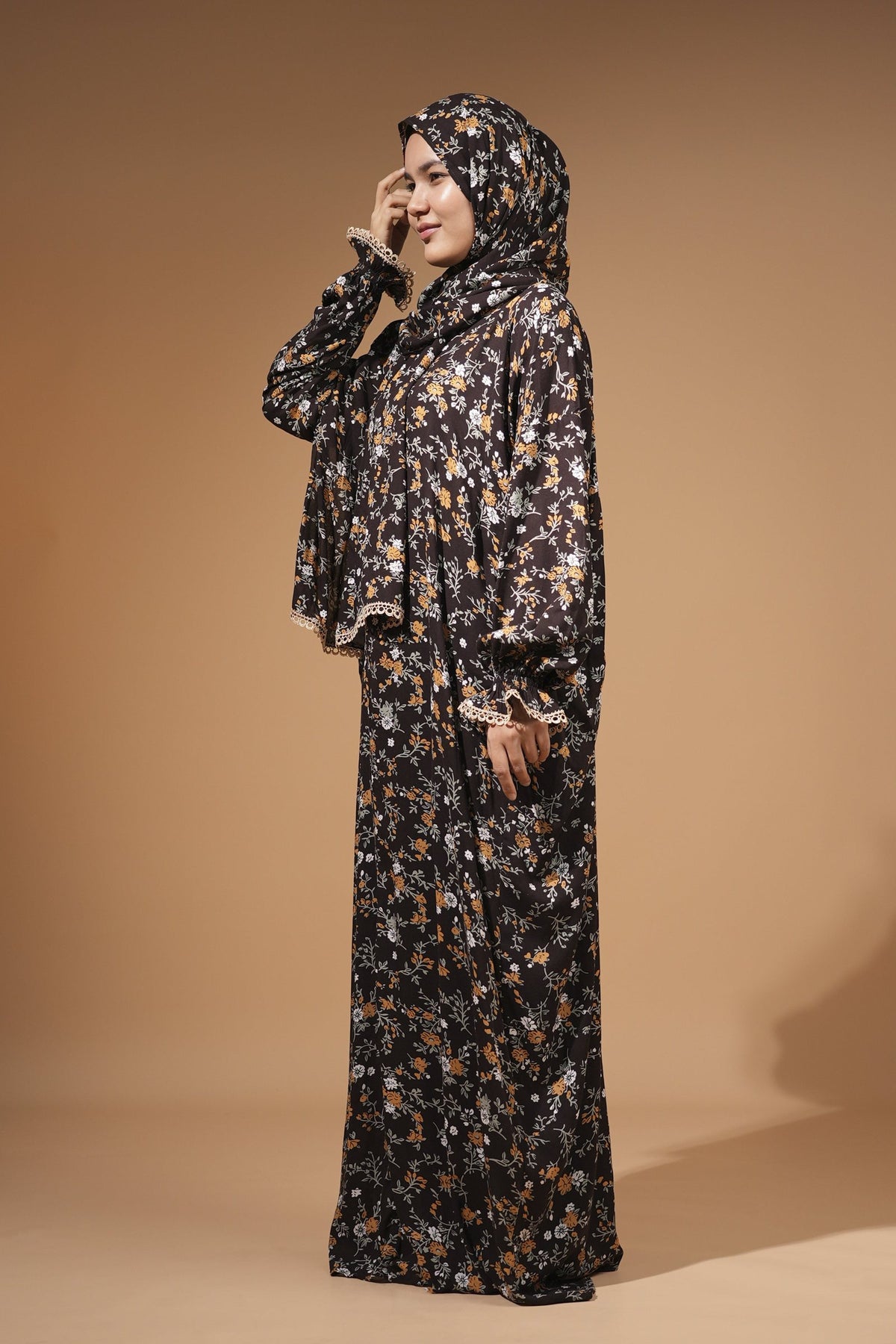 Woman wearing the dark floral maxi dress with built-in scarf, with orange and white flowers