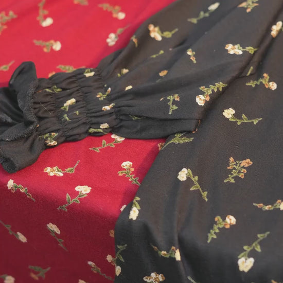 Video of the girls' cotton floral dresses with built-in scarf, showing the fabric and gathered cuffs
